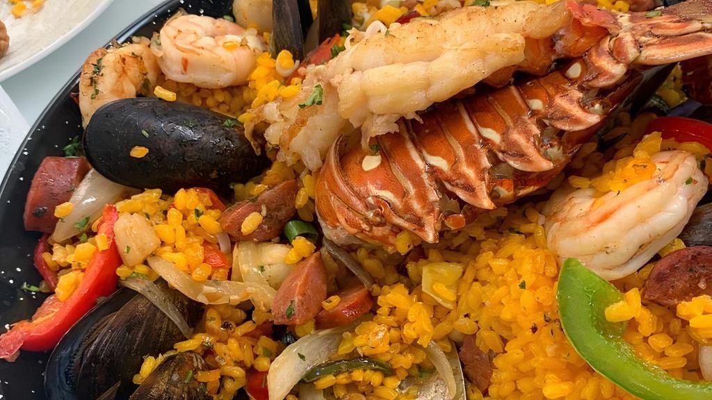 Seafood Paella · Spanish Chorizo-Saffron Rice, Lobster Tail, Scallops, Shrimp, Mussels, Red Bell Peppers, Green Peas, Sautéed Onions, and Chopped Parsley. Serves 2.