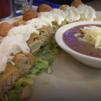 Flautas · 8 crispy chicken tacos with green tomatillo sauce, refried beans, and sour cream.