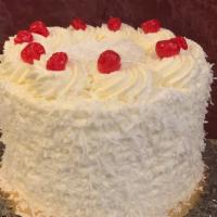 Coconut Cream Cake Slice · Moist white cake packed with fresh coconut cream decorated with fresh whipped cream and coco...