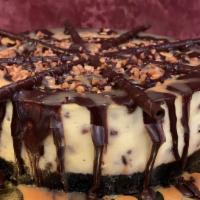 Turtle Cheesecake Slice · New York style cheesecake with an Oreo crust, baked with pecans and chocolate chips, topped ...