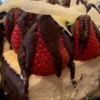 Strawberry Cheesecake Bar · Ny cheesecake topped with fresh strawberries drizzled chocolate and white chocolate shaving