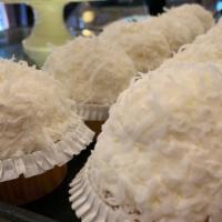 Coconut Cream Cupcake · White cake topped with coconut cream and rolled in coconut shavings.