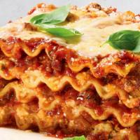 Lasagna · Three layers of tender pasta with creamy ricotta, ground beef, Romano cheese, homemade tomat...