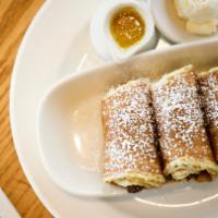 Three Little Pigs In A Blanket · Our special link sausages wrapped in buttermilk pancakes and dusted with powdered sugar. Ser...