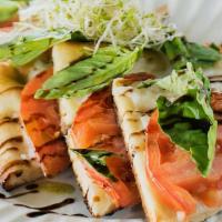 Caprese Pizzeta · Vegan mozzarella, tomato, fresh basil topped basil oil, balsamic glaze and sprouts