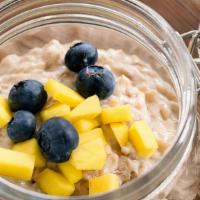 Coconut Rice Pudding (Gf) · Homemade coconut milk rice pudding, topped with fresh mango and blueberries