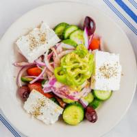 Horiatiki Village Greek Salad · Fresh vine-ripe tomatoes, cucumbers, green peppers, onions, feta cheese, olives, and extra v...