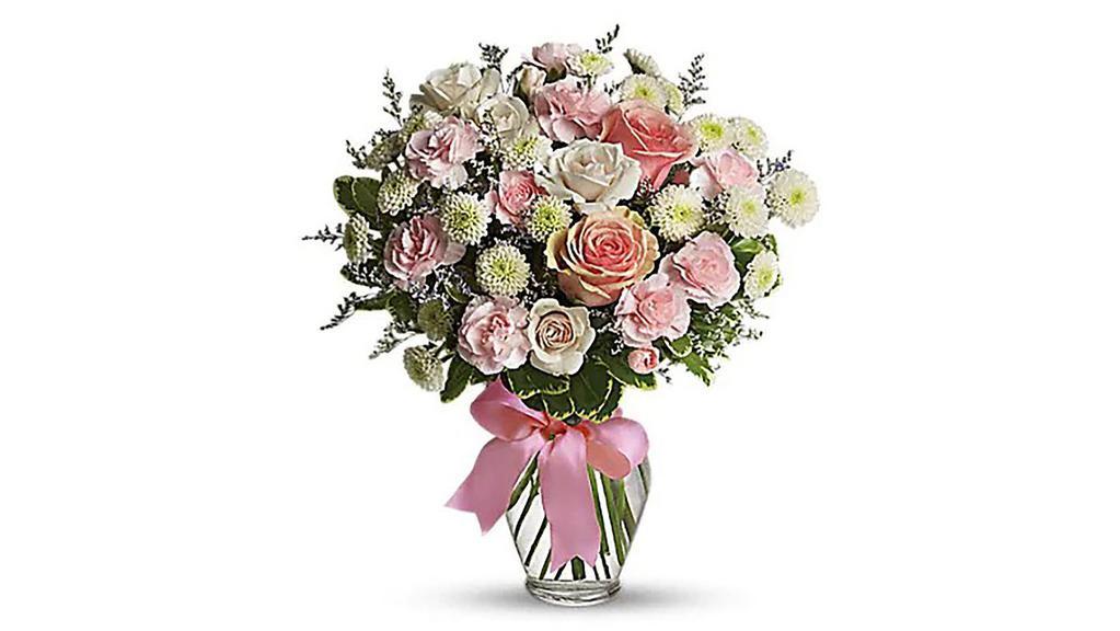 Cotton Candy Designers Choice · What a sweet way to celebrate the arrival of sugar and spice and everything nice! This pretty arrangement will delight any new mom or mom-to-be, that's for sure! Feminine flowers fill a charming ribbon-wrapped vase. It's a beautiful thing! Pretty pink roses, spray roses and miniature carnations, white button spray chrysanthemums, lavender limonium and green pittosporum fill a spring glass vase that's wrapped with a pink satin ribbon. It's confection perfection!