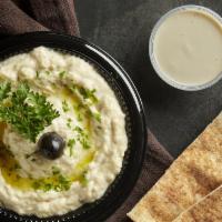Baba Ghanouj · Roasted eggplant blended with tahini, garlic and lemon juice, topped with paprika and extra ...