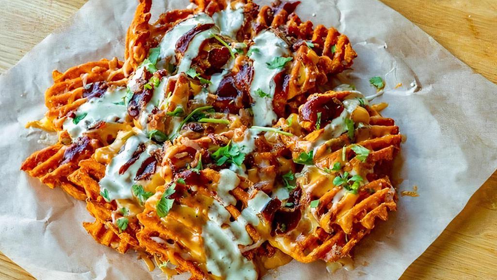 Loaded Sweets · Sweet Potato Waffle Fries fried to perfection topped with cheese, bacon, roasted jalapenos, pickled red onion, cilantro, BBQ and jalapeno ranch. Chipotle queso on the side.