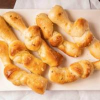 Garlic Knots · Pizza dough tied into knots, baked, and brushed with butter, garlic, and parmesan cheese. se...