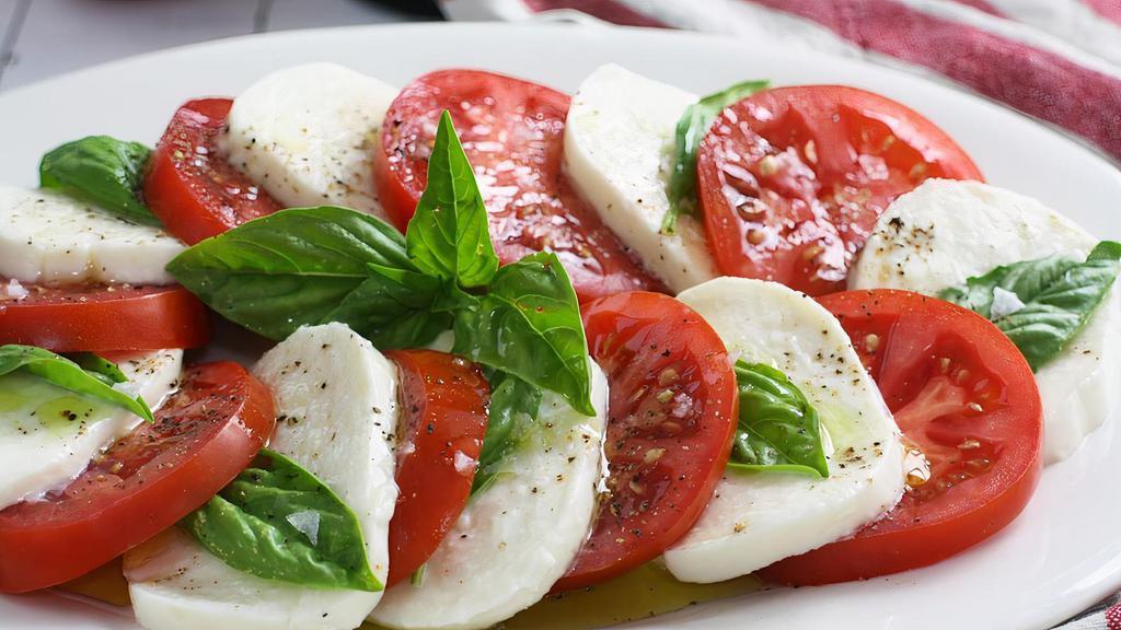 Caprese Salad · Sliced tomatoes, fresh mozzarella di bufala, croutons served with Italian olive oil
