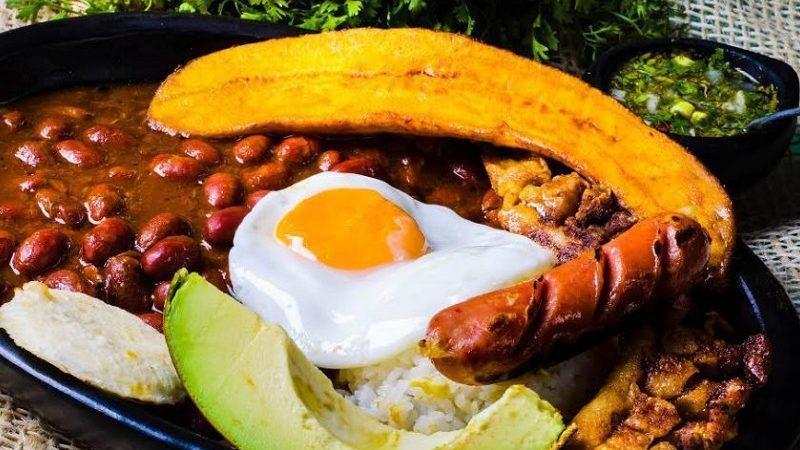 Bandeja Paisa · Paisa platter with beans, fried pork skin, Spanish sausage, rice, meat sweet plantain slices, fried egg and white corn cake.
