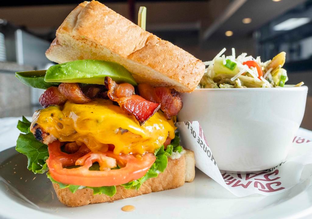 The 904 Club · Served on our buttery Texas toast, house-marinated grilled chicken breast, topped with melted Cheddar, pecan wood smoked bacon, crispy green leaf lettuce, tomato, red onion, house-made garlic aioli, and fresh avocado slices.
