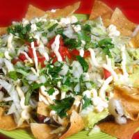 Nachos Supreme · Chips of tortillas, refried beans, lettuce, tomato, cilantro, onion, sour cream, melted chee...