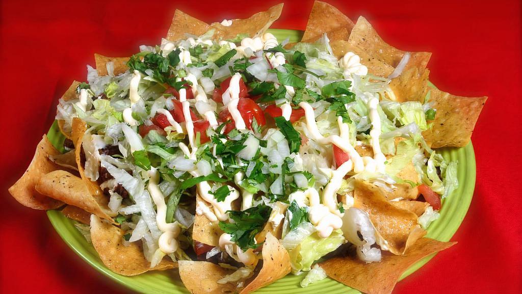 Nachos Supreme · Chips of tortillas, refried beans, lettuce, tomato, cilantro, onion, sour cream, melted cheese, and your choice of meat.