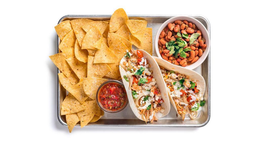 Chicken Tinga Taco Plate · Two tacos (1 flavor) containing chicken tinga, roasted onion and tomato, and crema. Served with ranchero beans, and chips & salsa.