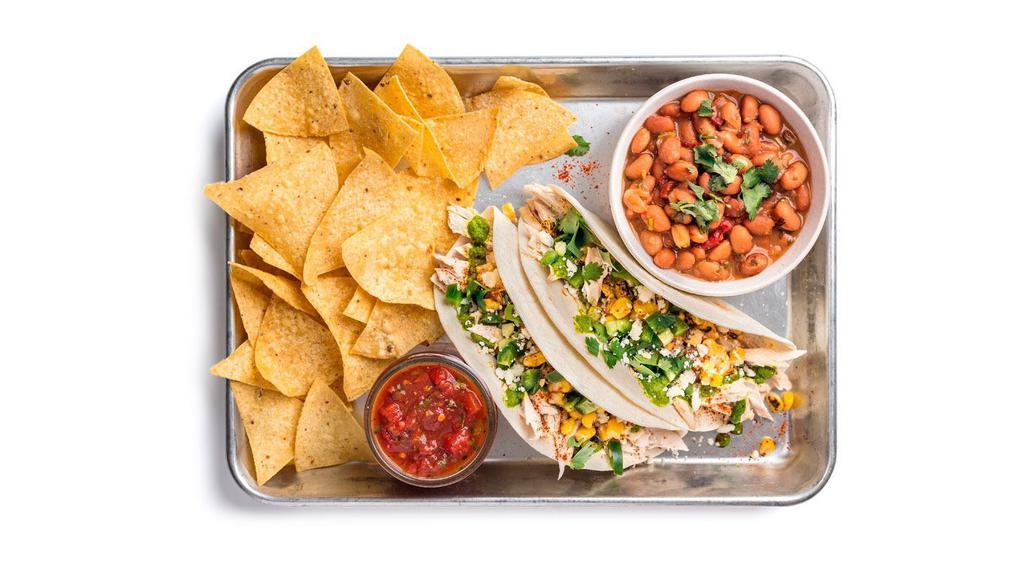 Elote Chicken Taco Plate · Two tacos (1 flavor) containing chicken, aji verde, street corn, and fresh jalapenos. Served with ranchero beans and chips & salsa.