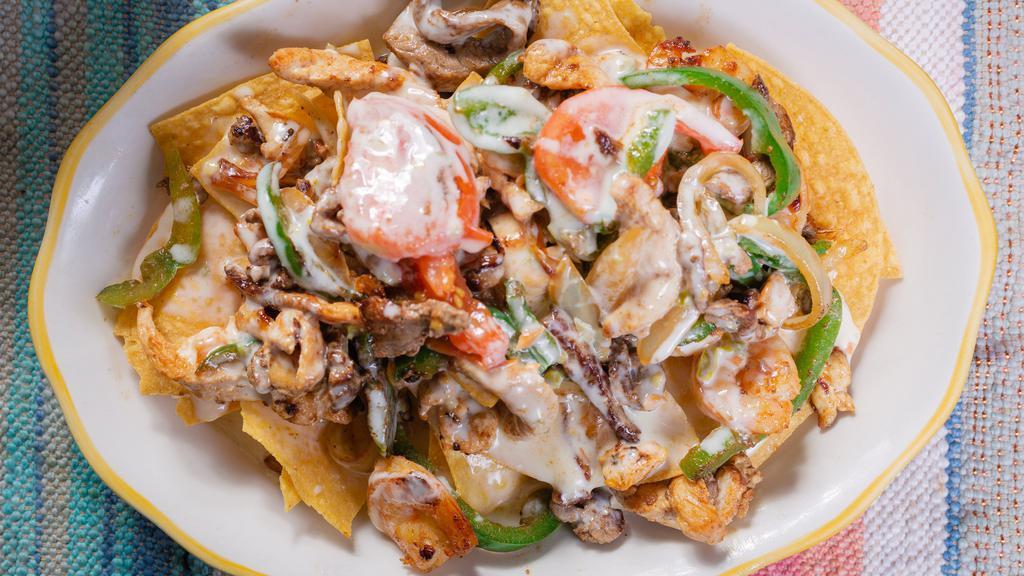 Fajita Nachos · Steak, chicken, and shrimp, grilled with onion, bell peppers, and tomatoes. Topped with nacho cheese.