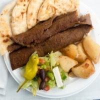Gyro Platter · Slices of gyro with lemon potatoes, Greek salad, and toasted pita bread.