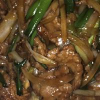 Mongolian Beef · Sliced tender flank beef tossed with scallion and yellow onion bedded on crispy rice noodle.