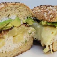Tropi Chicken Avocado Sandwich · Chicken salad, pineapple bites, bacon stripes, mozzarella,  1/2 avocado stripes on soft Hawa...