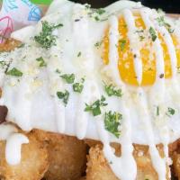 Truffle Breakfast Tater Tots · Truffle seasoned tater tots with a fried egg and topped with housemade lemon aioli and parme...