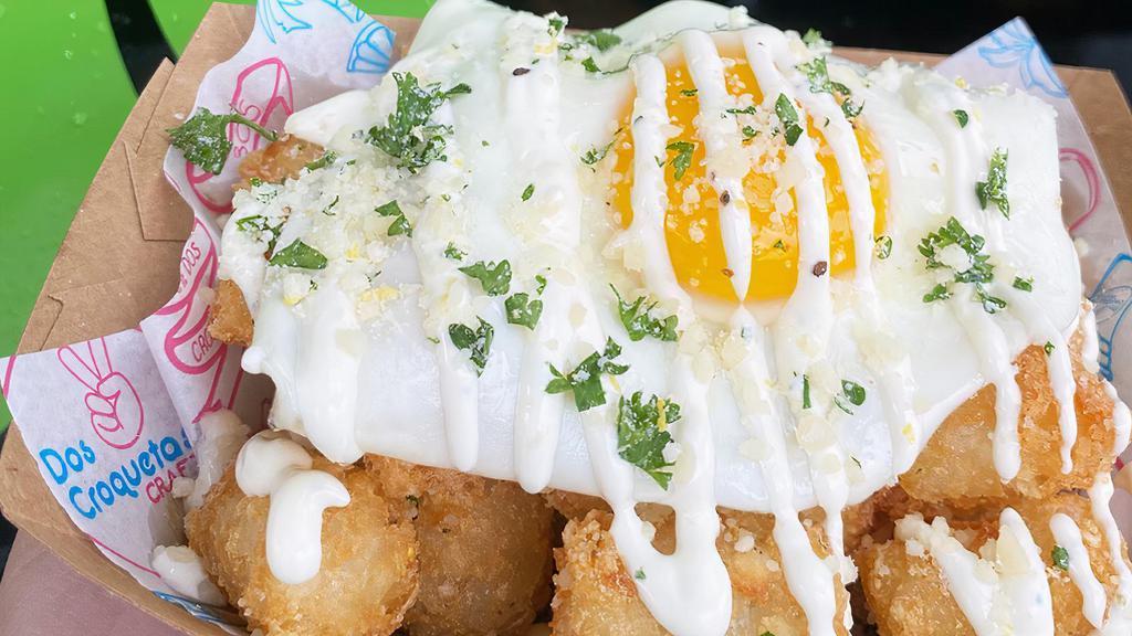 Truffle Breakfast Tater Tots · Truffle seasoned tater tots with a fried egg and topped with housemade lemon aioli and parmesan parsley with lemon zest
