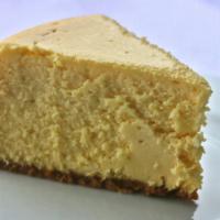 New York Style Cheesecake · A traditional slice of classic velvety cheesecake dusted with powdered sugar