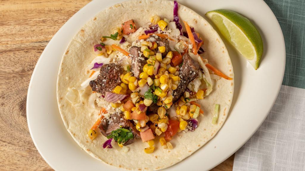 Steak And Street Corn Taco · Grilled sirloin steak with house slaw, roasted corn salsa, and cotija cheese on a flour tortilla