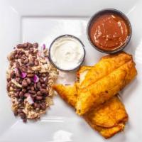 Chicken Empanadas · Fried flour tortilla filled with chicken, beans, and spicy cheese. Topped with sour cream an...