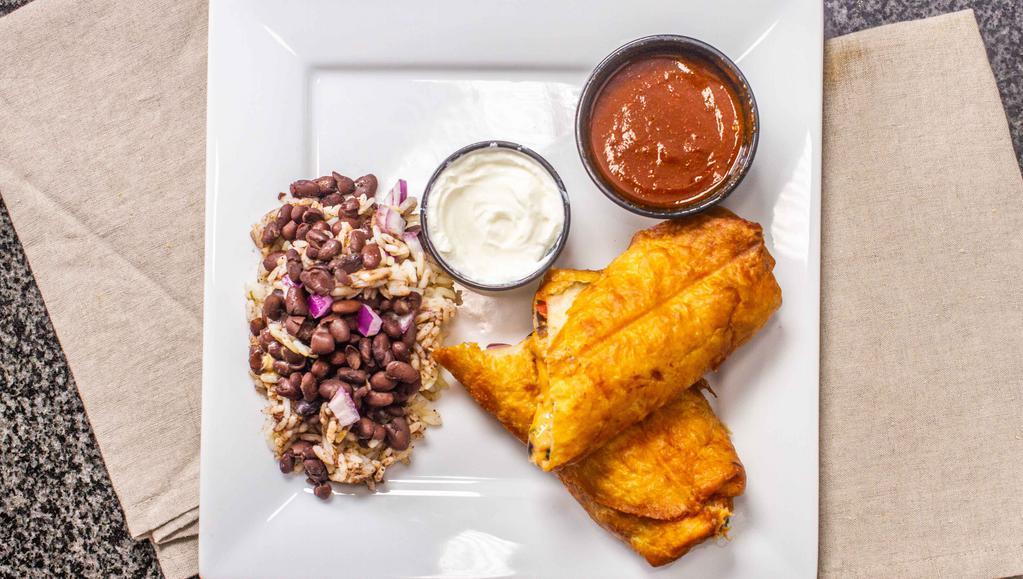 Chicken Empanadas · Fried flour tortilla filled with chicken, beans, and spicy cheese. Topped with sour cream and served with ranchero sauce, black beans and rice.