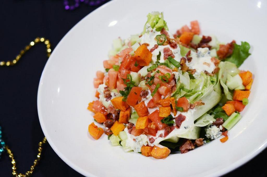 Bleu Cheese Wedge Salad · Crumbled bleu cheese, bacon, tomatoes, cucumbers and chives with bleu cheese dressing.