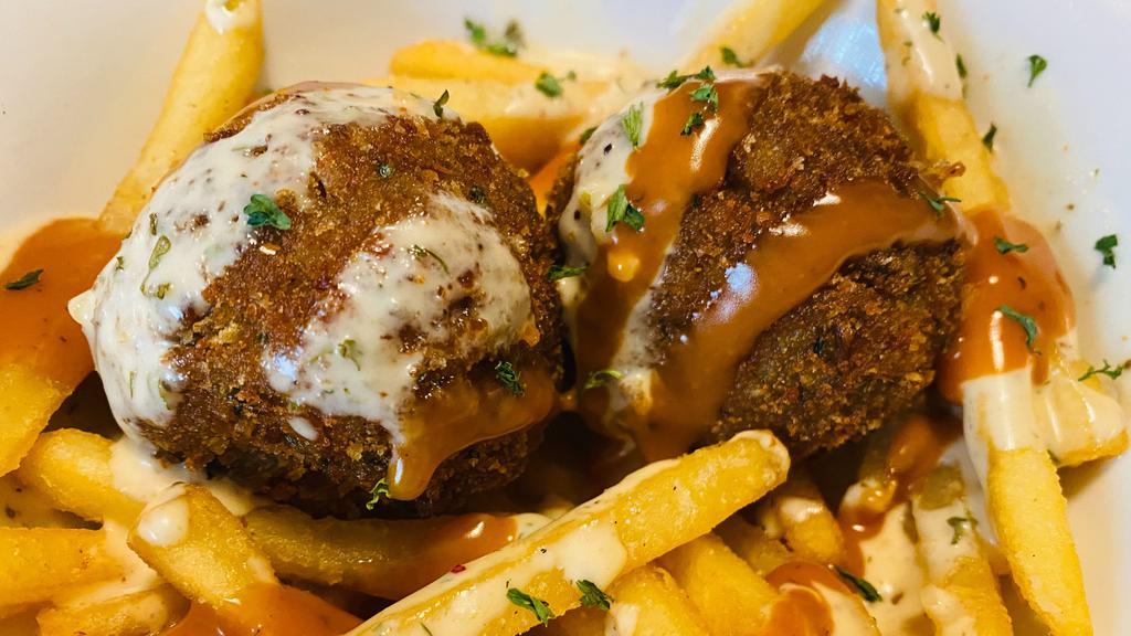 Boudin Ball Basket · Seasoned jackfruit, mushroom, and rice mixture rolled into a ball then breaded with breadcrumbs then deep fried golden brown served on top of crispy fries and house made sauces. GF Breadcrumbs available. Soy free