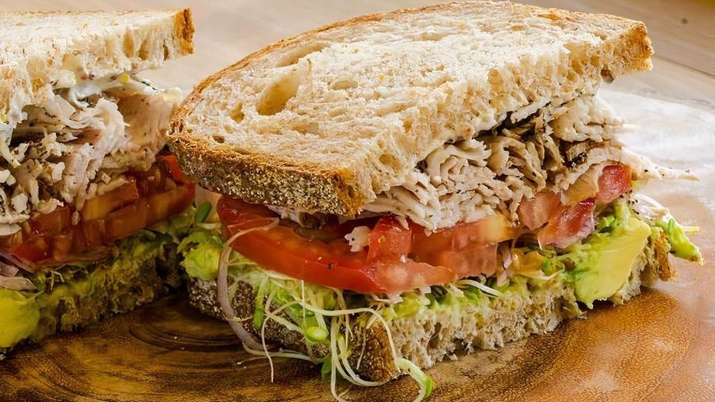 Peppered Turkey Sandwich · Smoked peppered turkey, sprouts, avocado, red onion, tomato, grainy mustard & mayonnaise, on house-made whole wheat bread.