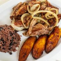 Lechón Asado (Roasted Pork) · Tender pork marinated in a cuban mojo, slow oven roasted and served with sauteed onions.