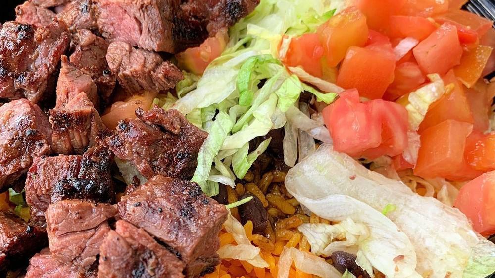 Latin Churrasco Chop · Chopped, specially marinated steak, white rice, black beans, lettuce, tomato, and pita.