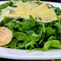 Arugula Salad · Arugula leaves tossed with extra virgin olive oil and lemon juice, topped with thin shavings...