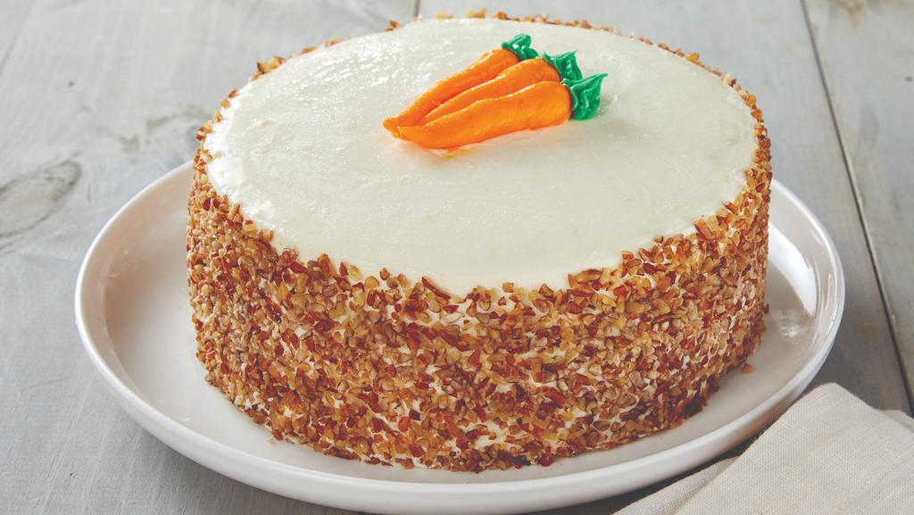 Carrot Cake · Our HoneyBaked Carrot Cake is the perfect culinary conclusion to any large meal or gathering. Each cake bursts with flavor and texture, thanks to multiple layers of high-quality ingredients. Every mouth-watering bite contains the perfect balance of fluffiness and melt-on-the-tongue creaminess.
 
Each HoneyBaked cake is stuffed with a rich mixture of fresh shredded carrots, walnuts and sweet raisins. A smooth cream cheese frosting is spread over the top and between each cake layer to create visual interest and decadent flavor with each bite. A crunchy layer of fresh chopped pecans is gently sprinkled across the surface of the cake to provide the perfect finishing touch.