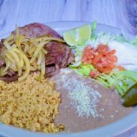 Carne Asada · Steak sliced thin and grilled. Served with refried beans, rice, lettuce, tomatoes, onions, g...