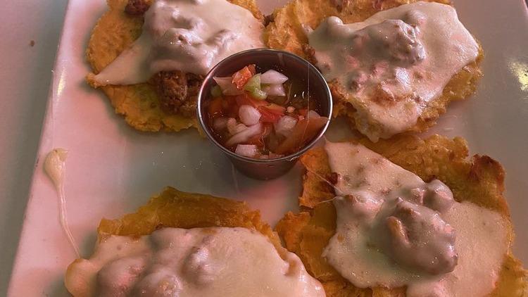 Tostones Nica · Four Hawaiian plantains topped with homemade chorizo and melted Mozzarella cheese.