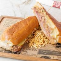 Cubano Sandwich · A Cuban classic served with ham, roasted pork, swiss cheese, pickles, and mustard. Served in...