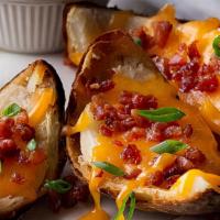 Crispy Skins · Cheesy, crispy potato skins topped with cheddar, bacon, sour cream and green onions