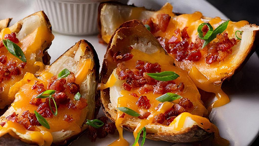Crispy Skins · Cheesy, crispy potato skins topped with cheddar, bacon, sour cream and green onions