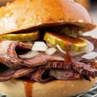 Badass Brisket · Low and slow-cooked prime brisket topped with tangy BBQ on a toasted bun. Served with onions...