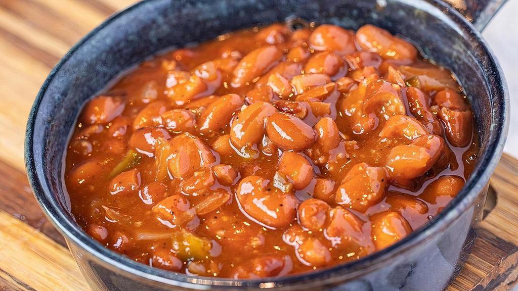 Baked Beans · Ranch style beans baked slow with a skosh of beer, onions, jalapenos and BBQ sauce