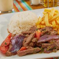 Lomo Saltado · Peruvian style stir-fried marinated strips of beef steak, onion and tomatoes, served with wh...