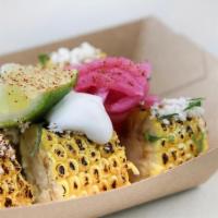 Corn On The Cob · A corn cob charred and served with crema, pickled red onions & queso fresco.