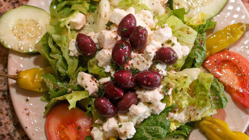 Greek Salad · Fresh mixture of tomatoes, cucumbers, Greek peppers, kalamata olives, and feta cheese tossed in our Greek vinaigrette with pita bread on a bed of lettuce. Prepared with extra virgin olive oil.