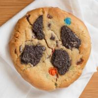 Conflicted Cookie · Cookie dough mixed with chocolate chips, peanut butter chips,m&m's and topped with oreo chunks
